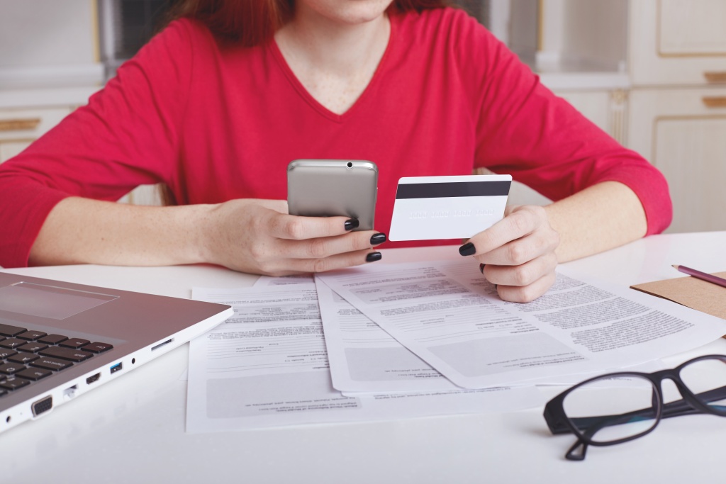 unrecognizable-female-model-red-sweater-sits-working-table-surrounded-with-papers-laptop-computer.jpg телефон